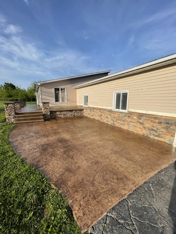 D5C2BA70-A551-4EB8-8679-44E18DFE2CE7_4_5005_c Single story beige house with stone accents, patio, and green lawn Cody X Pressure Washing