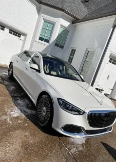 white-car White luxury sedan on wet driveway in front of modern white house; Cody-X service. Cody-X Pressure Washing