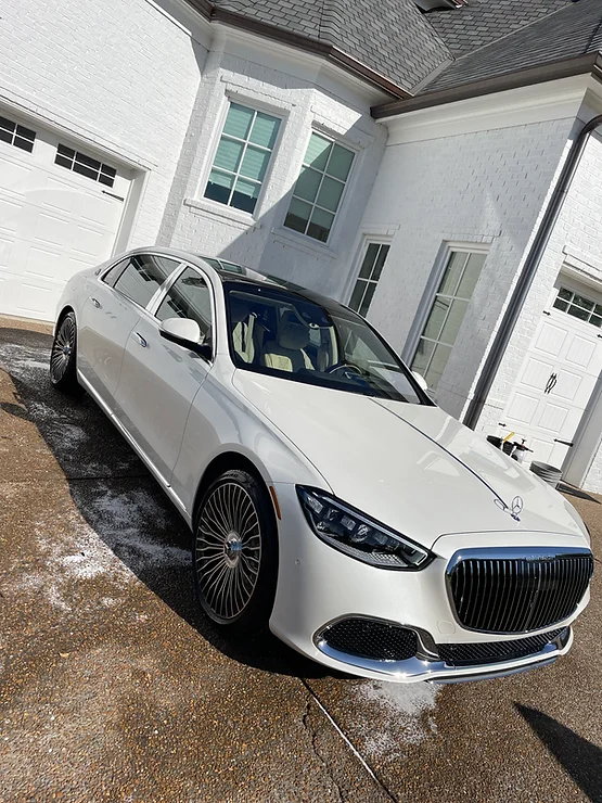 white-car White luxury sedan on wet driveway in front of modern white house; Cody X service Cody X Pressure Washing