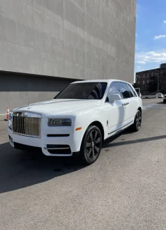 IMG_4544-scaled White Rolls-Royce SUV parked by a concrete building under sunny skies. Cody-X Pressure Washing