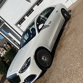 ef9505_ff6d58e40bf34ce1a84ed07d5b09a143mv2.webp White luxury sedan on driveway by garage with modern homes and trees Cody X pressure washing and concrete sealing service Cody X Pressure Washing