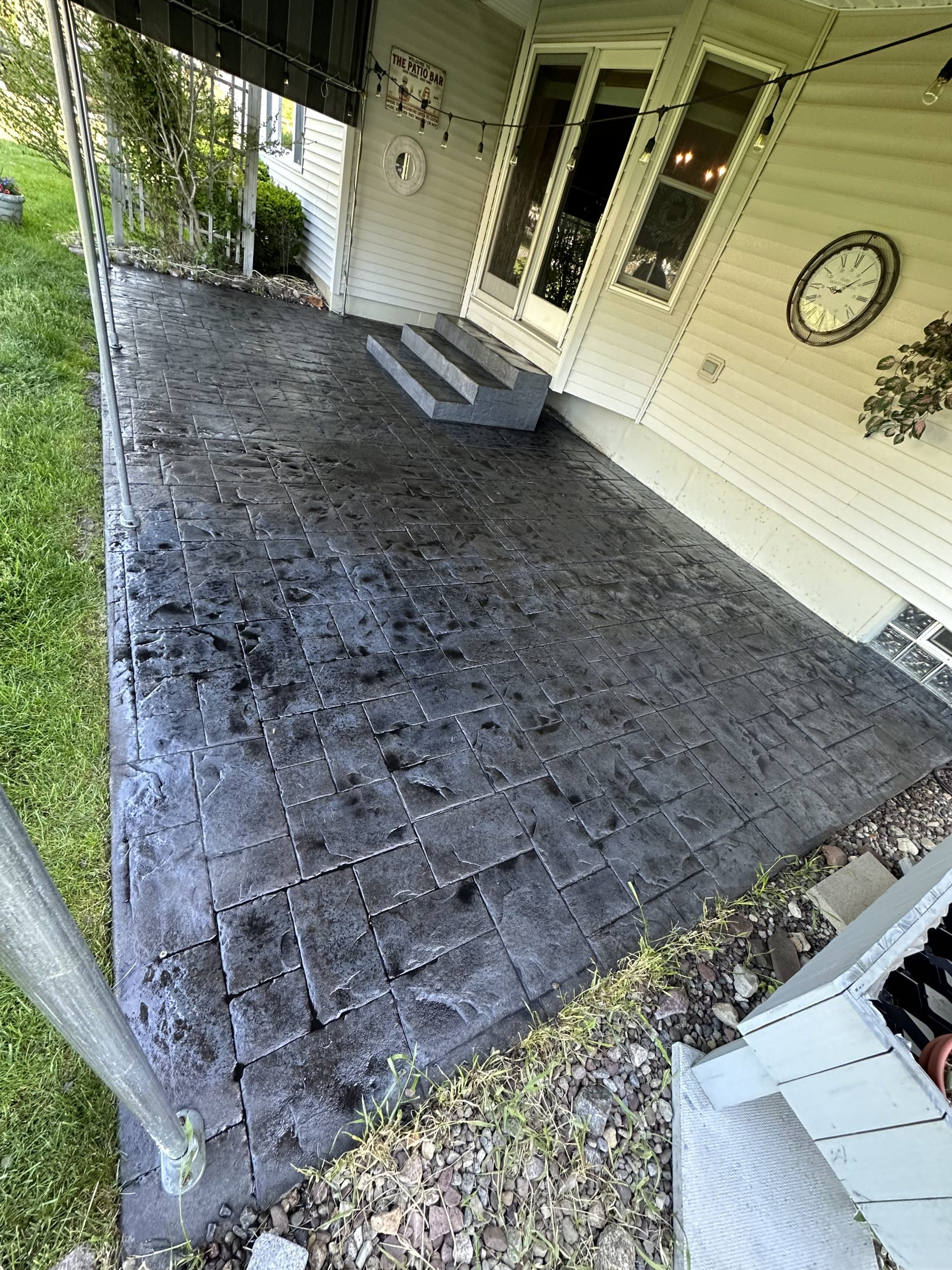 Photo May 27 2023, 9 03 00 AM Stamped concrete patio with slate pattern by steps and double doors, Cody X service Cody X Pressure Washing