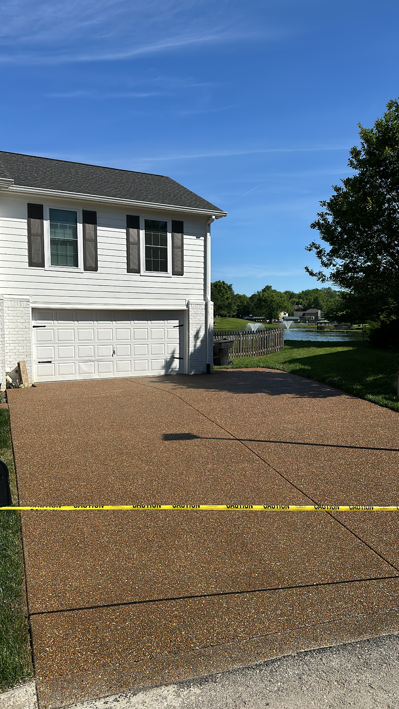 CF3F8A94-3C70-4EA1-9B1D-DF6757A4B170 House with double garage, new driveway, and yellow caution tape in front Cody X Pressure Washing