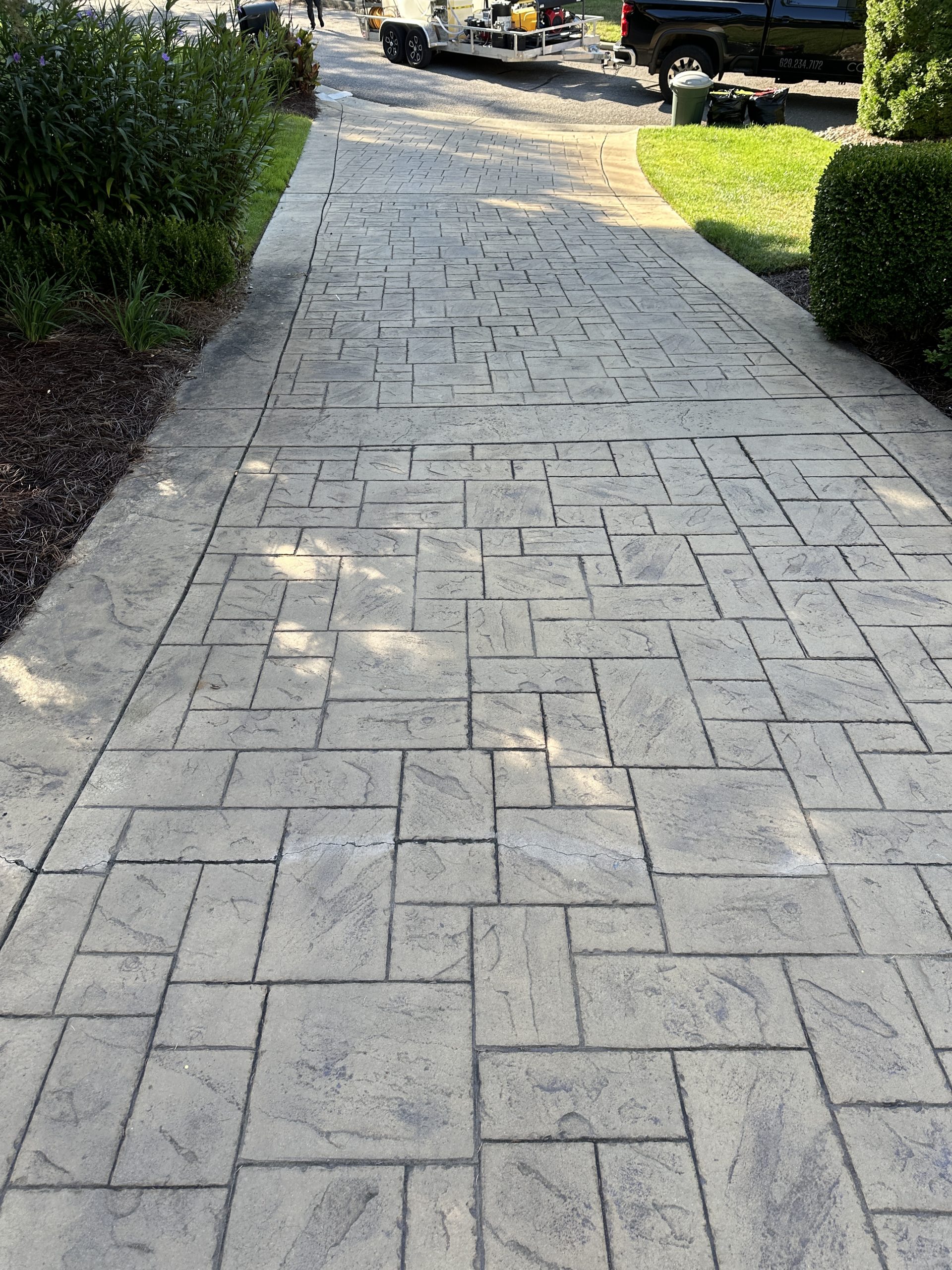 IMG_0380 Stamped concrete walkway leads through landscaped yard to driveway with trailers Cody X Pressure Washing
