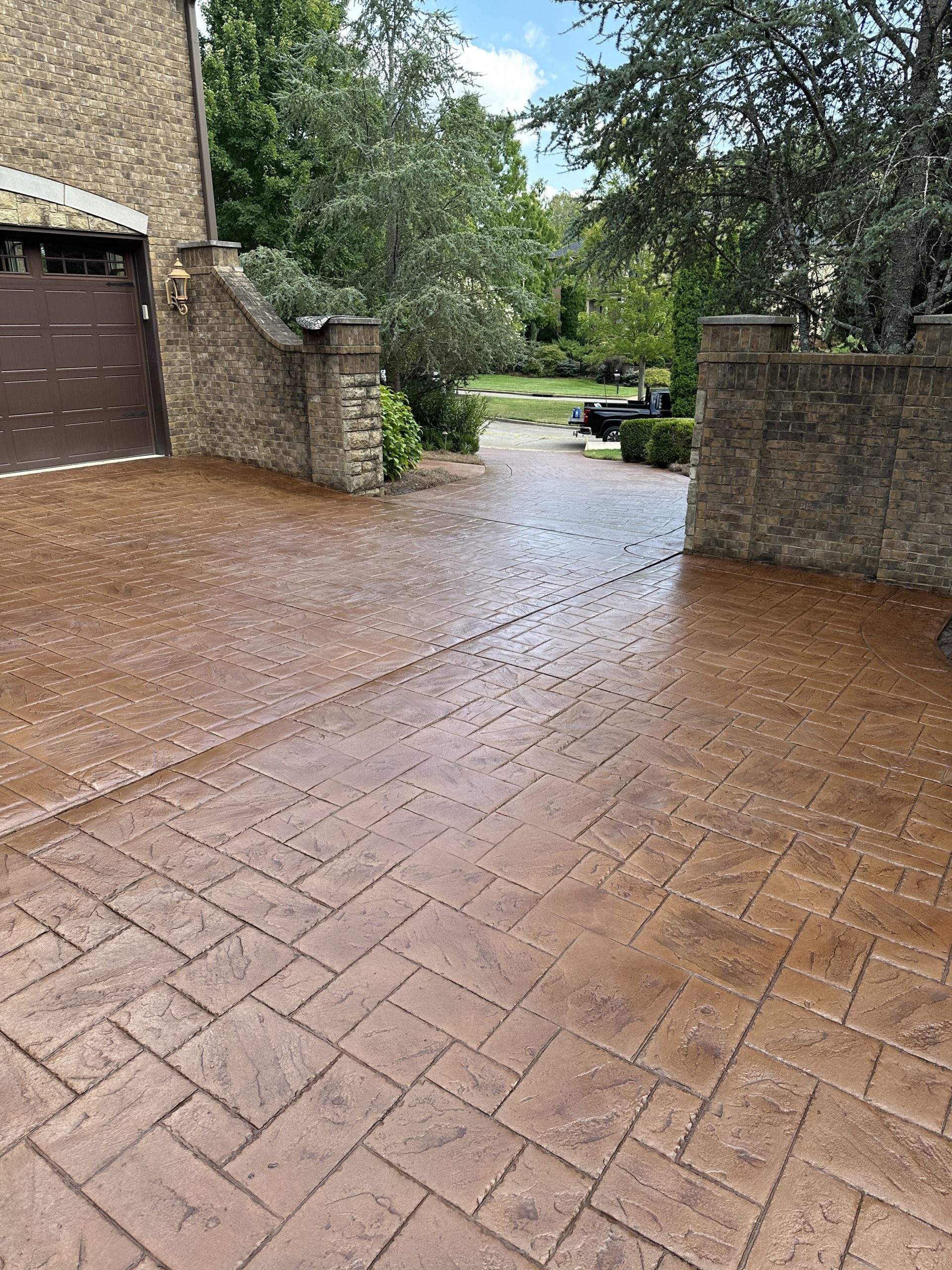IMG_0401 Stamped herringbone concrete driveway with brick borders and vibrant landscaping Cody X Pressure Washing