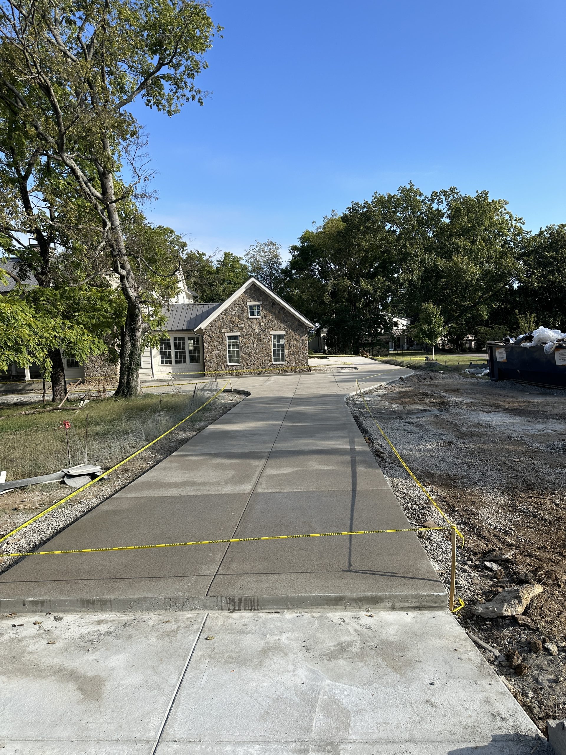 IMG_0646 Fresh concrete driveway to brick house, caution tape and materials at right Cody X Pressure Washing