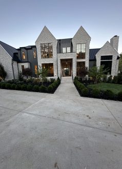 IMG_0662 Modern gray brick two-story house with driveway, landscaping, and big windows. Cody-X Pressure Washing