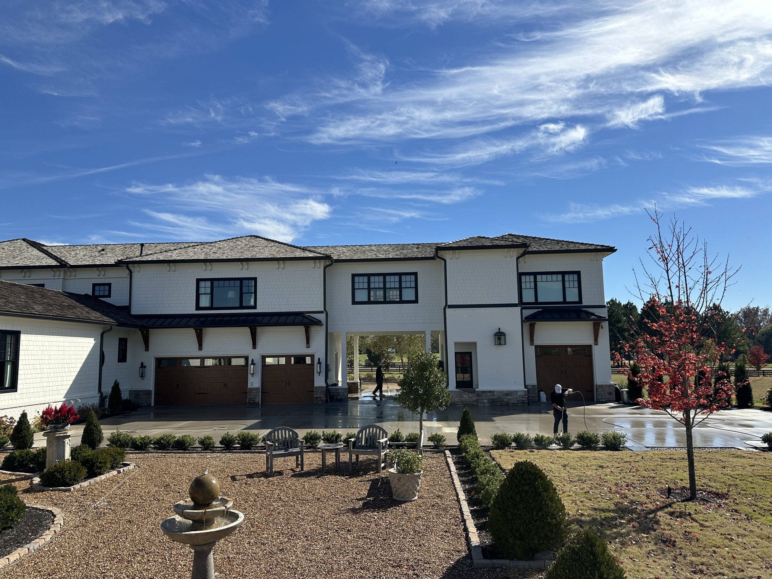IMG_1116 White modern house with three wooden garages, landscaped yard, sunny day Cody X Pressure Washing