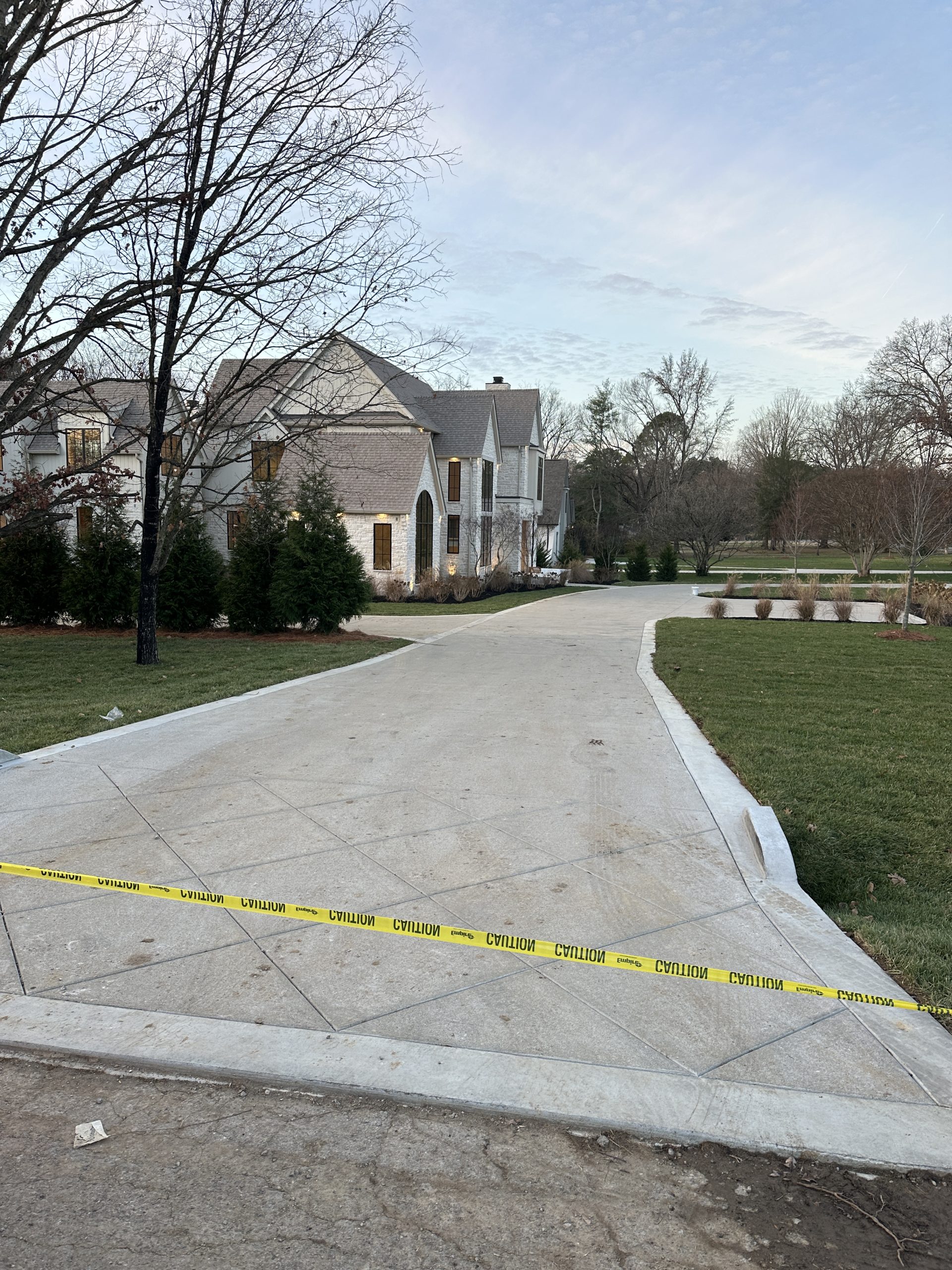 IMG_1983 Cody X sealed driveway blocked by caution tape; lush trees, green lawn Cody X Pressure Washing
