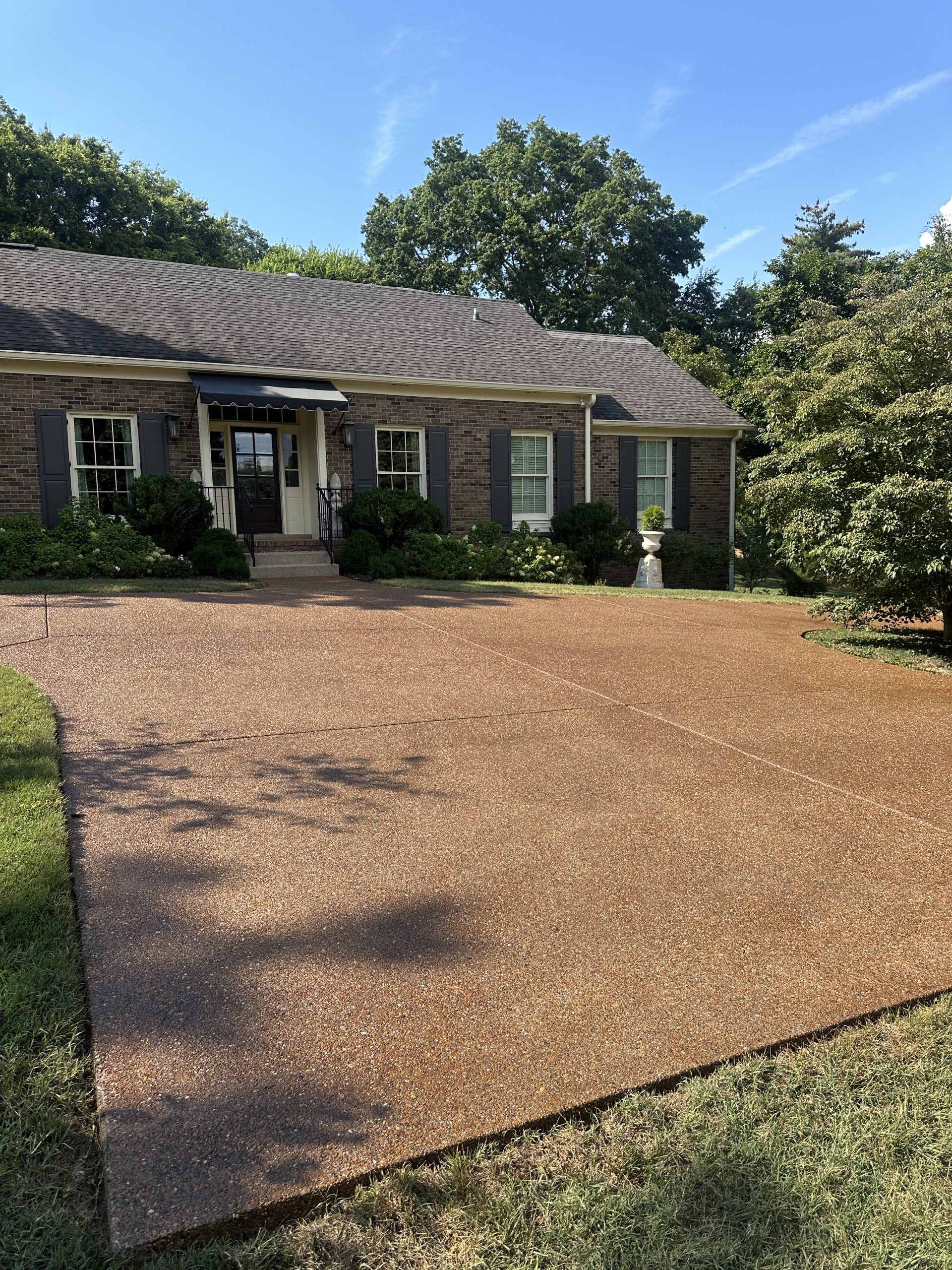 IMG_9974 A brick house with black shutters, neat driveway, green shrubs, blue sky Cody X Pressure Washing
