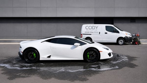 detailing-hero A white sports car on wet pavement near a detailing van and equipment Cody X Pressure Washing